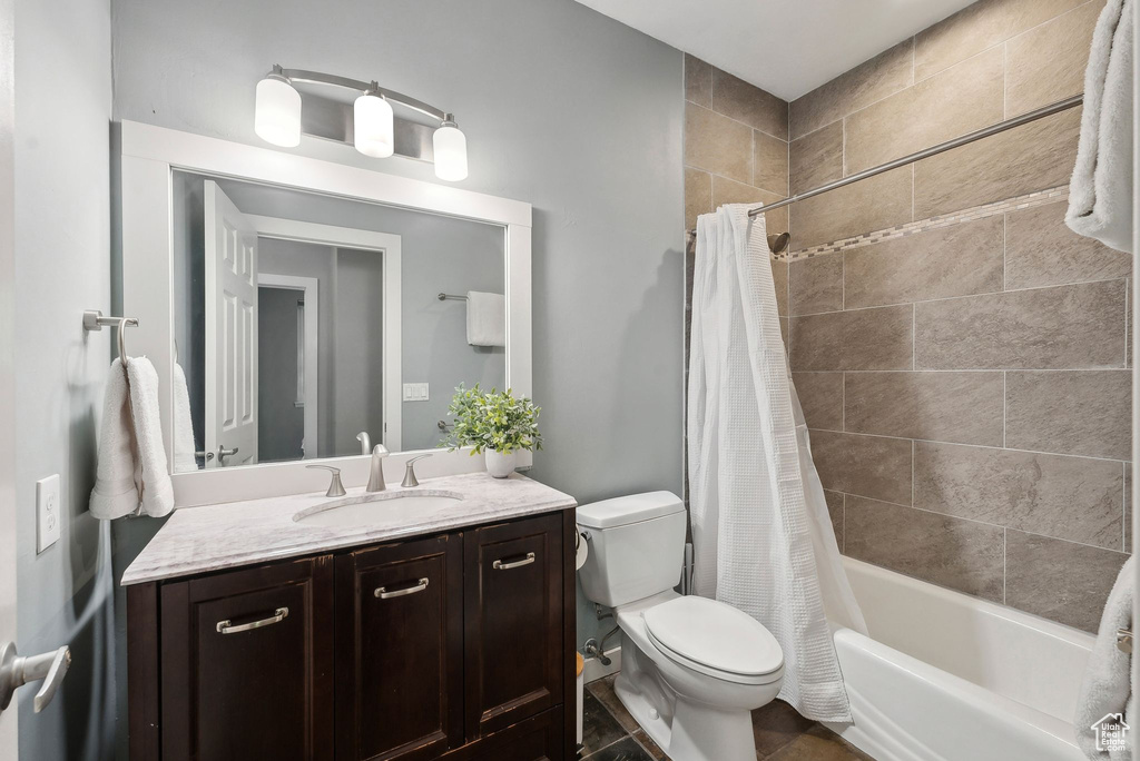 Full bathroom featuring vanity, tile patterned flooring, toilet, and shower / bath combo