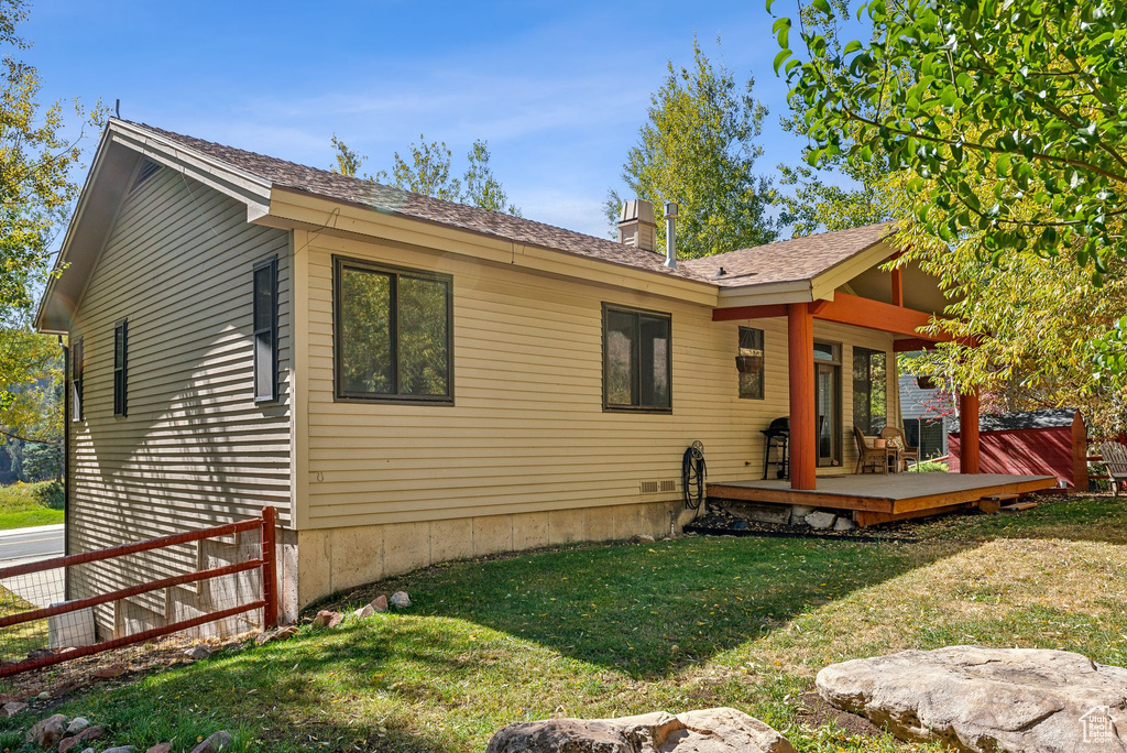 Back of house featuring a deck and a lawn