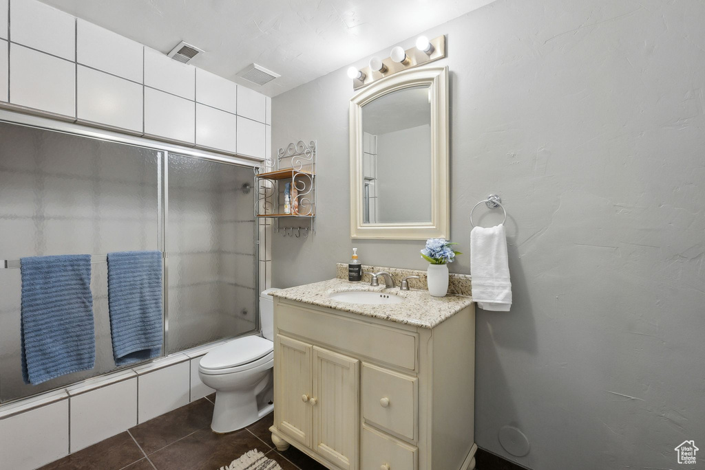 Full bathroom with washtub / shower combination, tile patterned flooring, vanity, and toilet