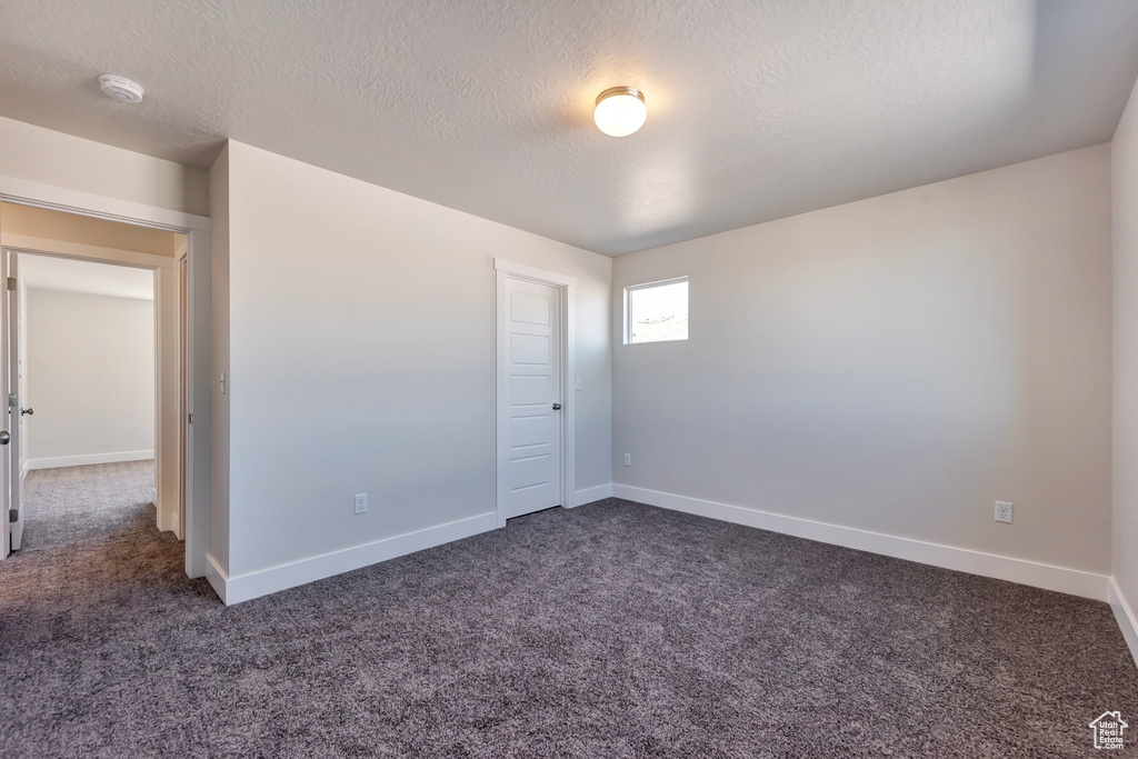 Carpeted empty room with a textured ceiling