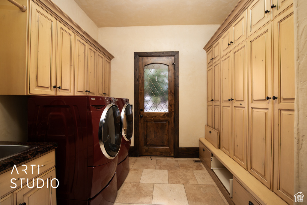 Clothes washing area featuring independent washer and dryer and cabinets