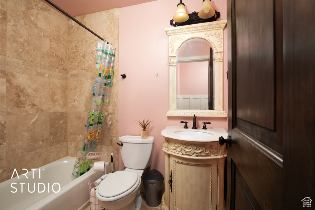 Full bathroom featuring vanity, toilet, and shower / bathtub combination with curtain