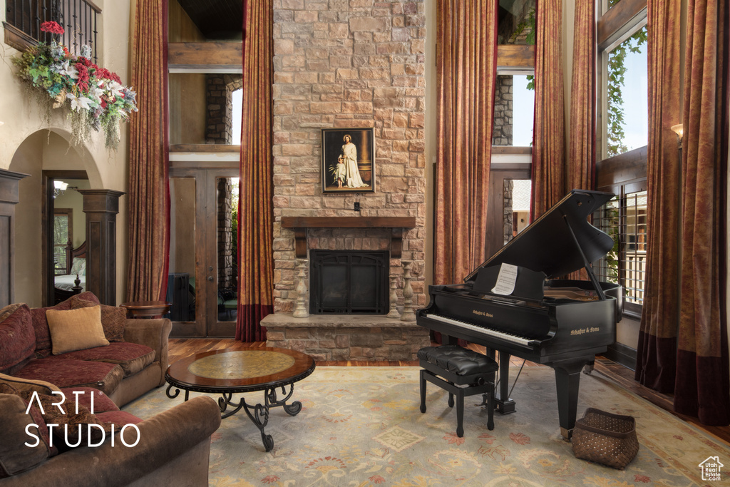 Interior space with a high ceiling, decorative columns, a fireplace, and wood-type flooring