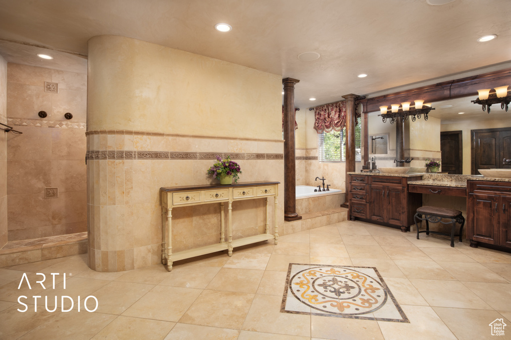 Bathroom with vanity, tile walls, ornate columns, tile patterned floors, and independent shower and bath