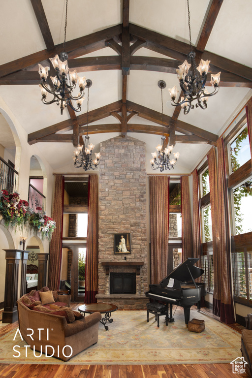 Living room with high vaulted ceiling and light hardwood / wood-style flooring