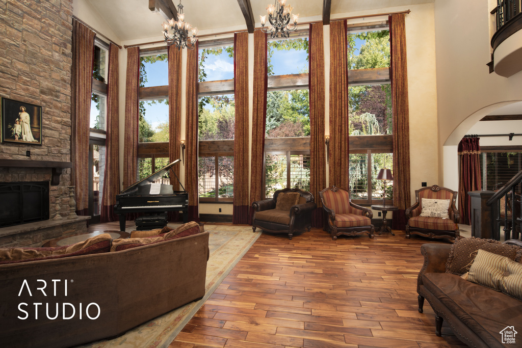 Living room featuring a notable chandelier, plenty of natural light, a fireplace, and hardwood / wood-style floors