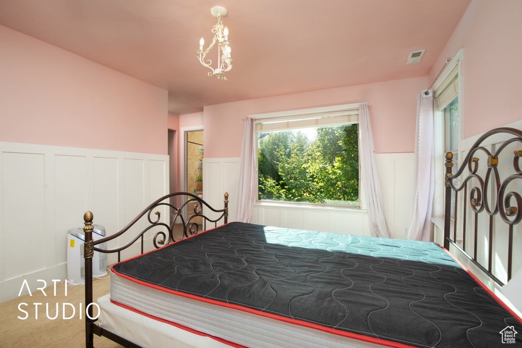 Carpeted bedroom with a notable chandelier