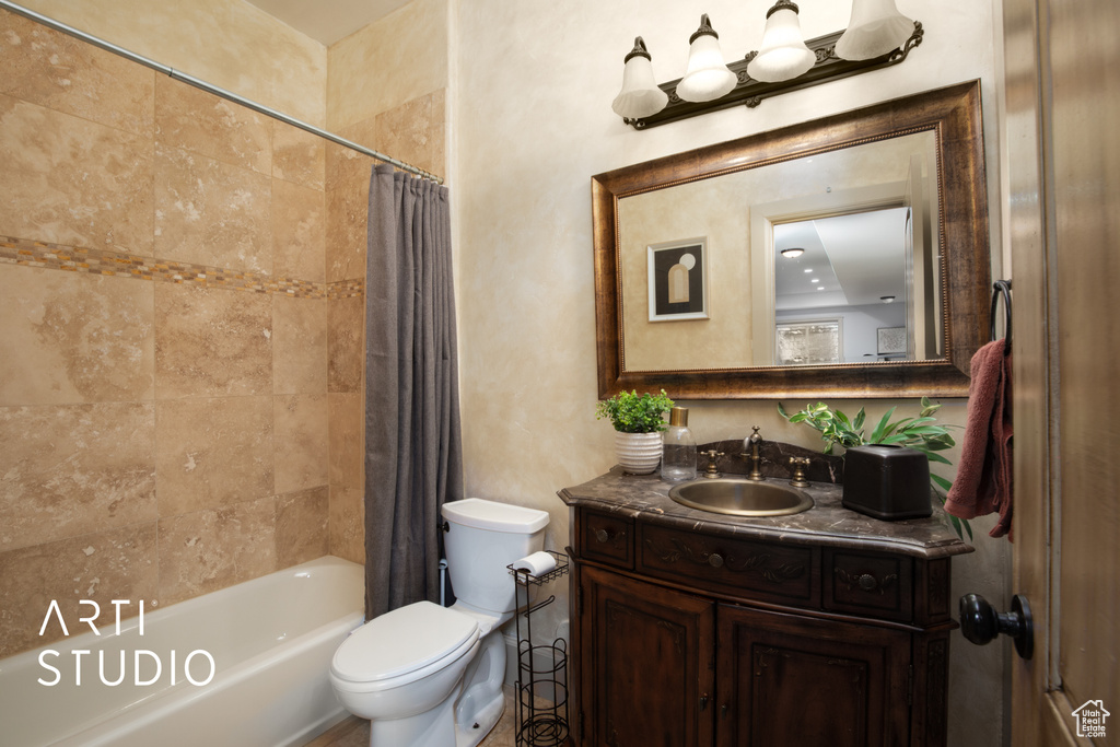 Full bathroom with shower / bath combination with curtain, vanity, and toilet
