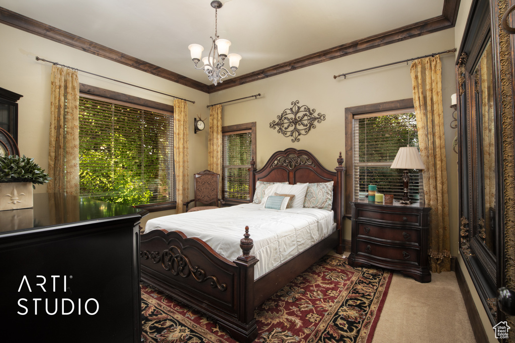 Carpeted bedroom featuring ornamental molding and a notable chandelier