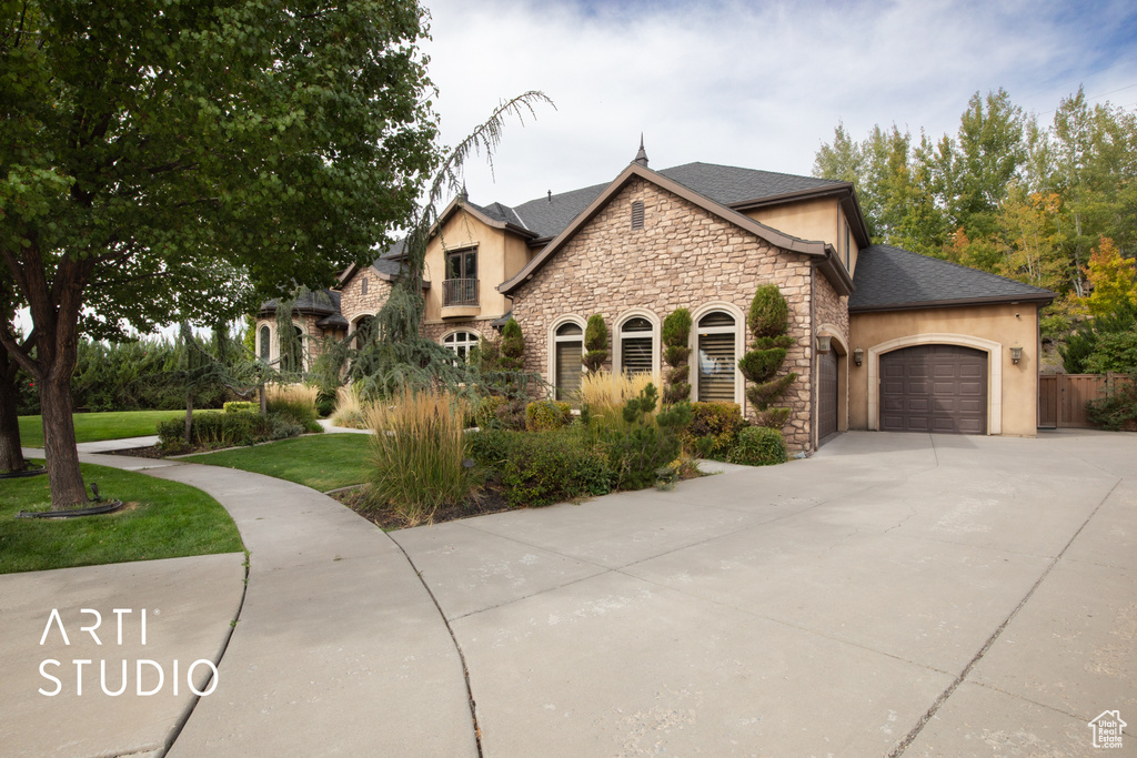 French country home featuring a front yard and a garage