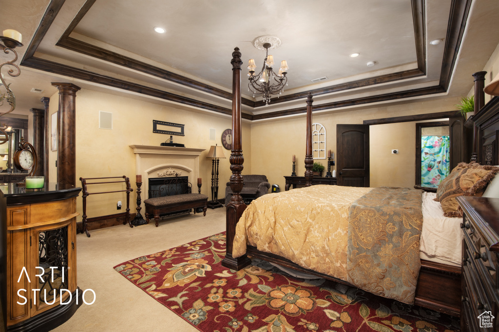 Bedroom featuring light carpet, a tray ceiling, crown molding, and a chandelier