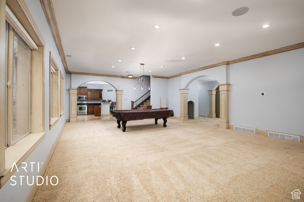 Playroom with ornate columns, crown molding, light colored carpet, and billiards