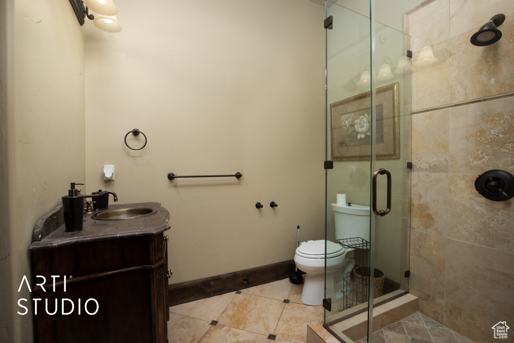 Bathroom with vanity, toilet, a shower with door, and tile patterned floors