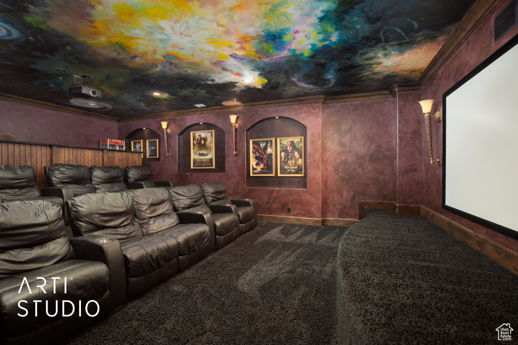 Carpeted cinema room featuring ornamental molding