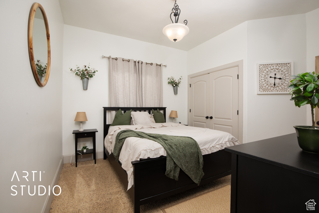 Bedroom with light carpet and a closet