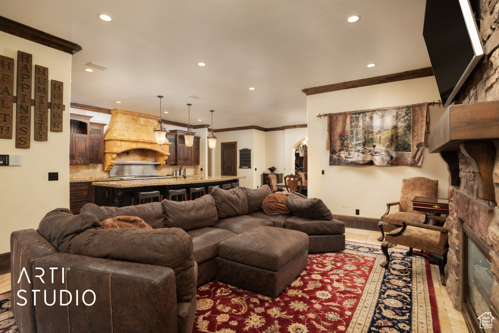 Living room featuring light tile patterned floors, sink, and ornamental molding