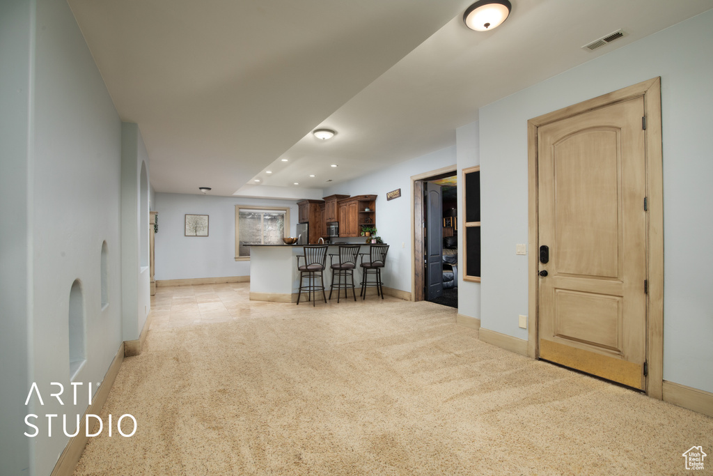 Unfurnished living room featuring light carpet