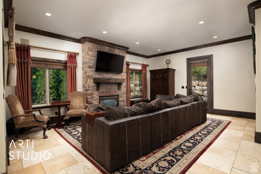 Living room featuring crown molding and a stone fireplace