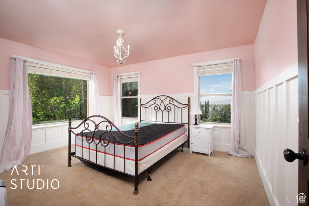 Bedroom featuring a chandelier and light carpet