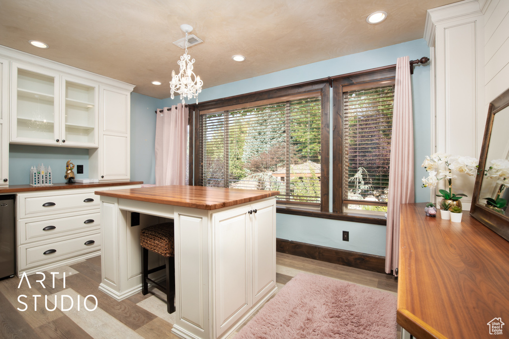 Kitchen featuring butcher block counters, a wealth of natural light, pendant lighting, and light hardwood / wood-style flooring