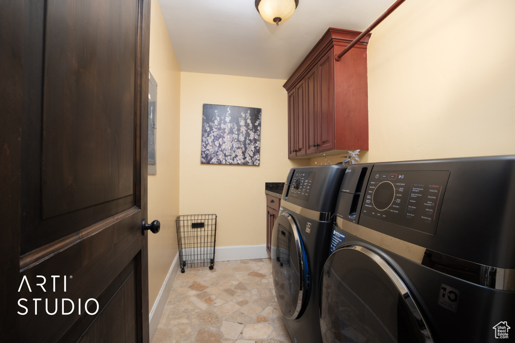 Washroom with washer and dryer and cabinets