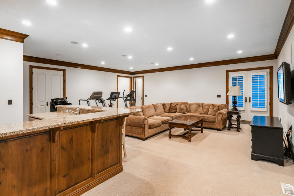 Living room with french doors, light colored carpet, and crown molding