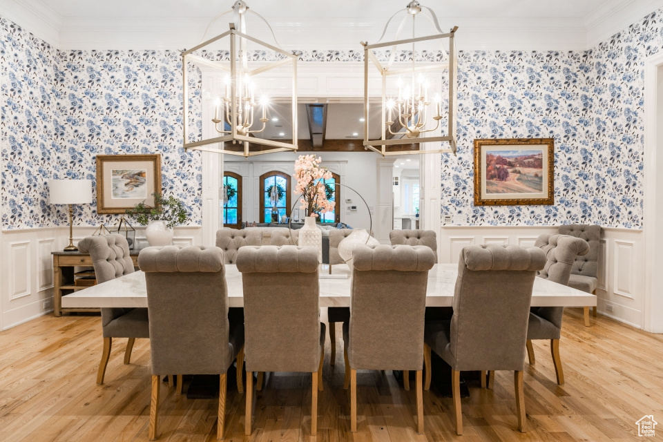 Dining room with ornamental molding, a notable chandelier, and wood-type flooring