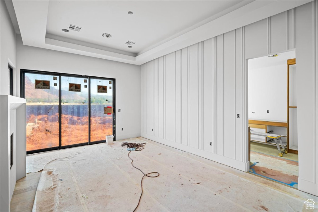 Unfurnished room with a tray ceiling and a healthy amount of sunlight