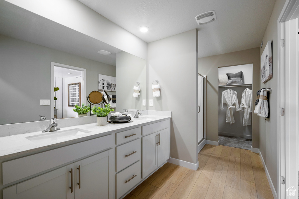 Bathroom with vanity, hardwood / wood-style floors, and an enclosed shower