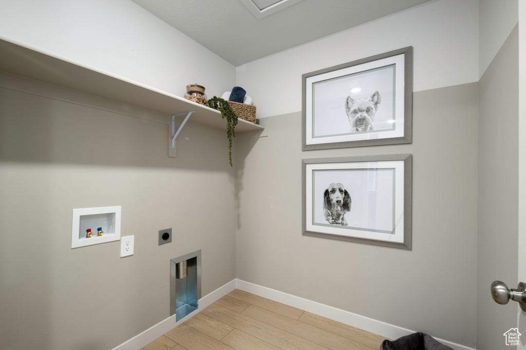 Clothes washing area featuring washer hookup, light hardwood / wood-style floors, and electric dryer hookup