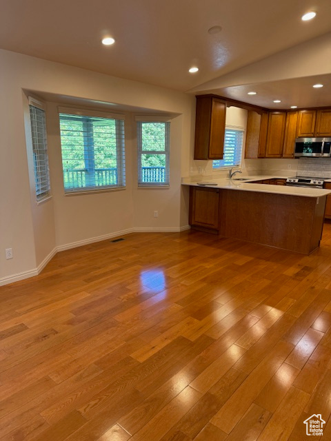 Kitchen with sink, light hardwood / wood-style floors, and kitchen peninsula