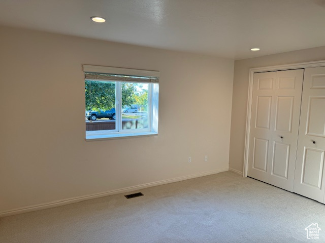Unfurnished bedroom with a closet and light colored carpet