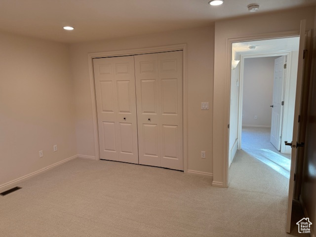 Unfurnished bedroom with a closet and light colored carpet