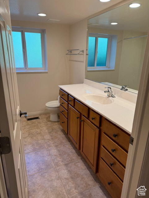 Bathroom featuring vanity, tile patterned flooring, and toilet