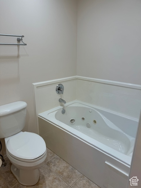Bathroom featuring a bathing tub, tile patterned floors, and toilet