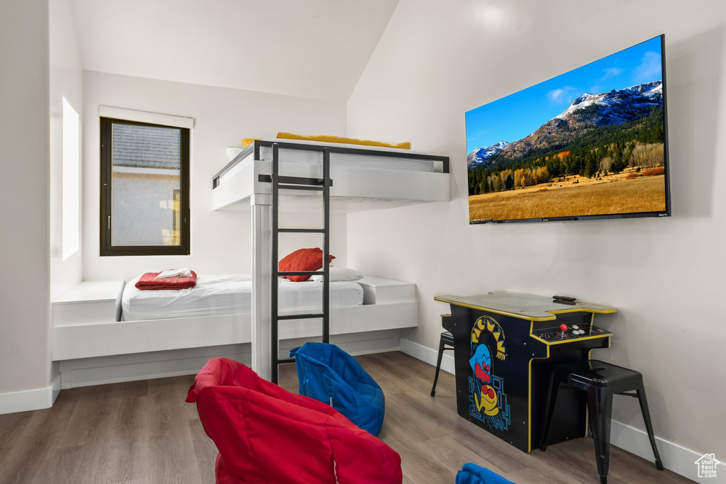 Bedroom with lofted ceiling and wood-type flooring