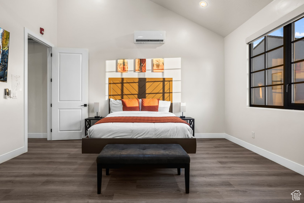 Bedroom with high vaulted ceiling, a wall unit AC, and dark hardwood / wood-style floors