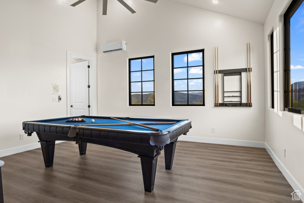 Playroom featuring dark wood-type flooring, ceiling fan, high vaulted ceiling, and a wall mounted air conditioner