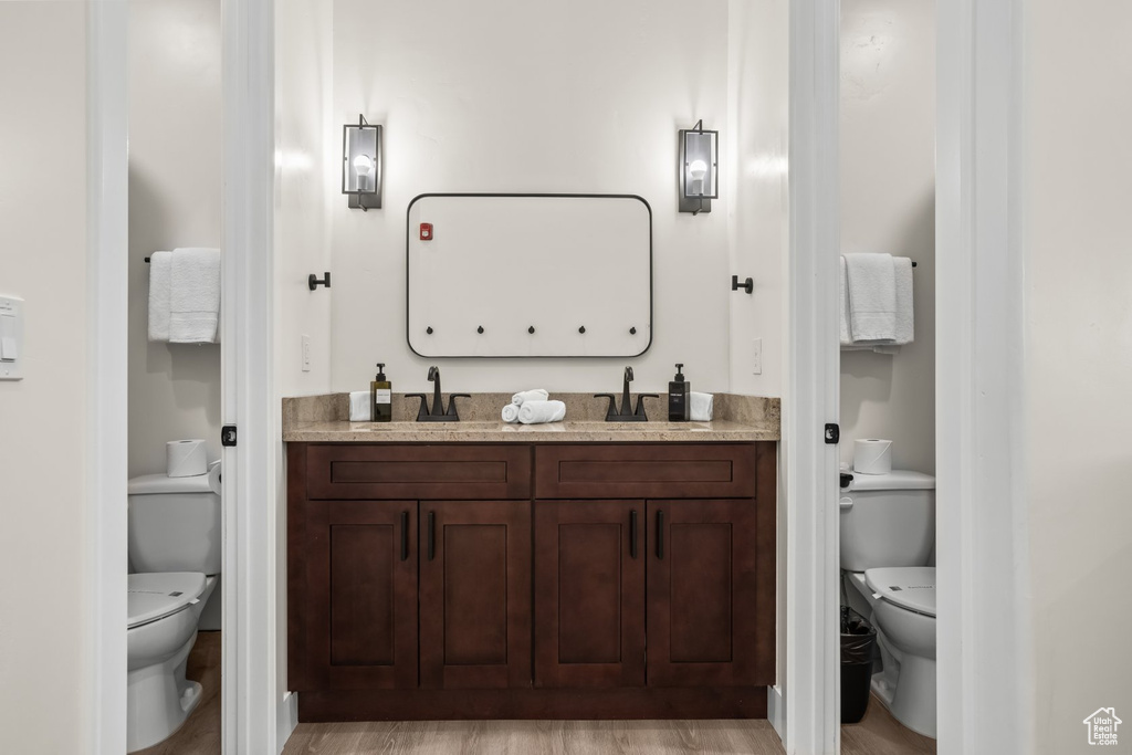 Bathroom with vanity, hardwood / wood-style floors, and toilet