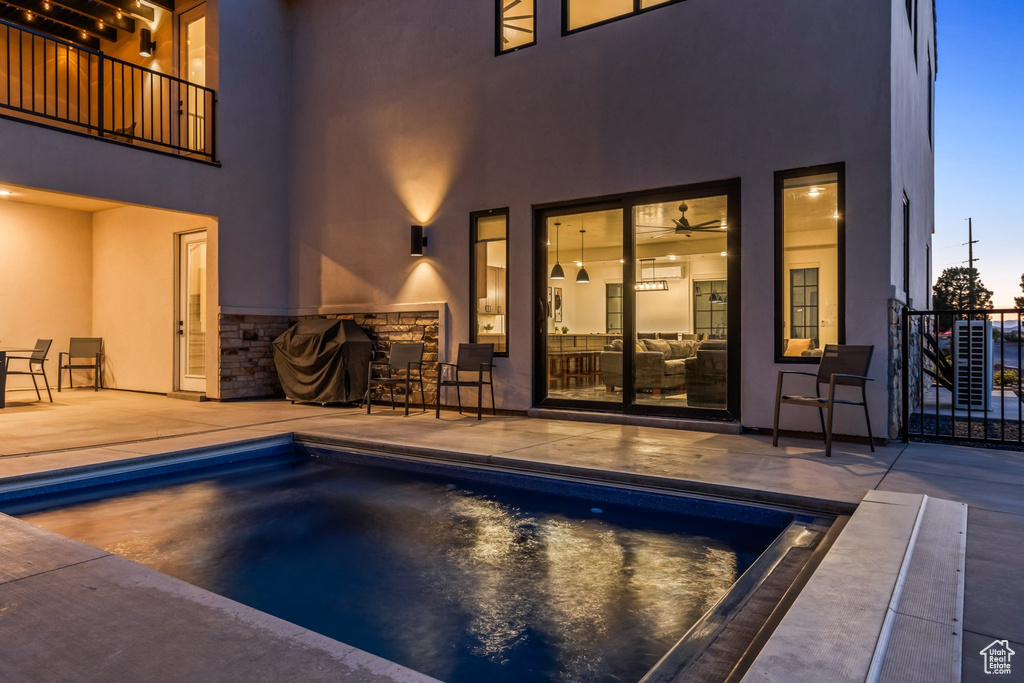 Pool at dusk featuring a patio