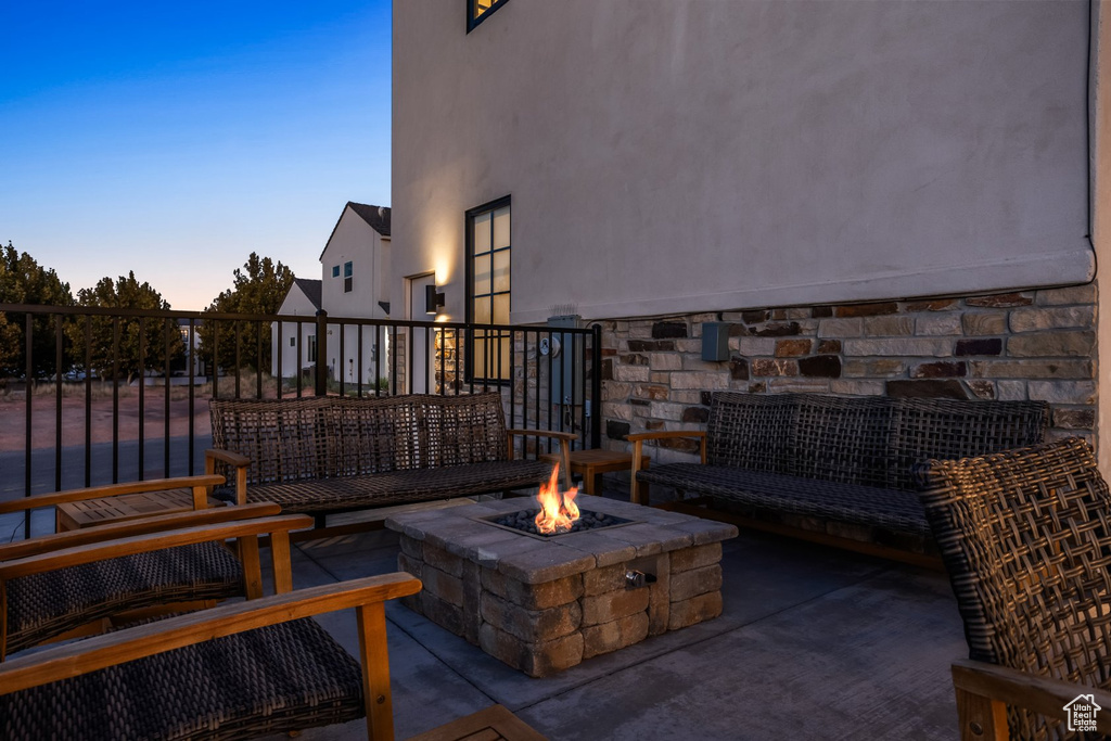 Patio terrace at dusk with an outdoor living space with a fire pit