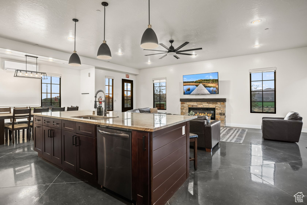 Kitchen featuring pendant lighting, an island with sink, plenty of natural light, and sink