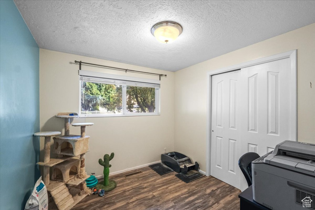 Home office featuring a textured ceiling and dark wood-type flooring