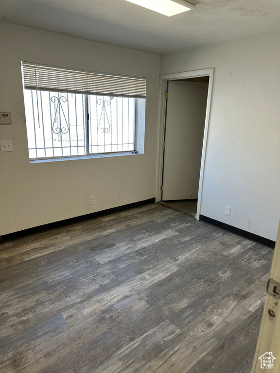 Unfurnished room with dark hardwood / wood-style floors and a wealth of natural light