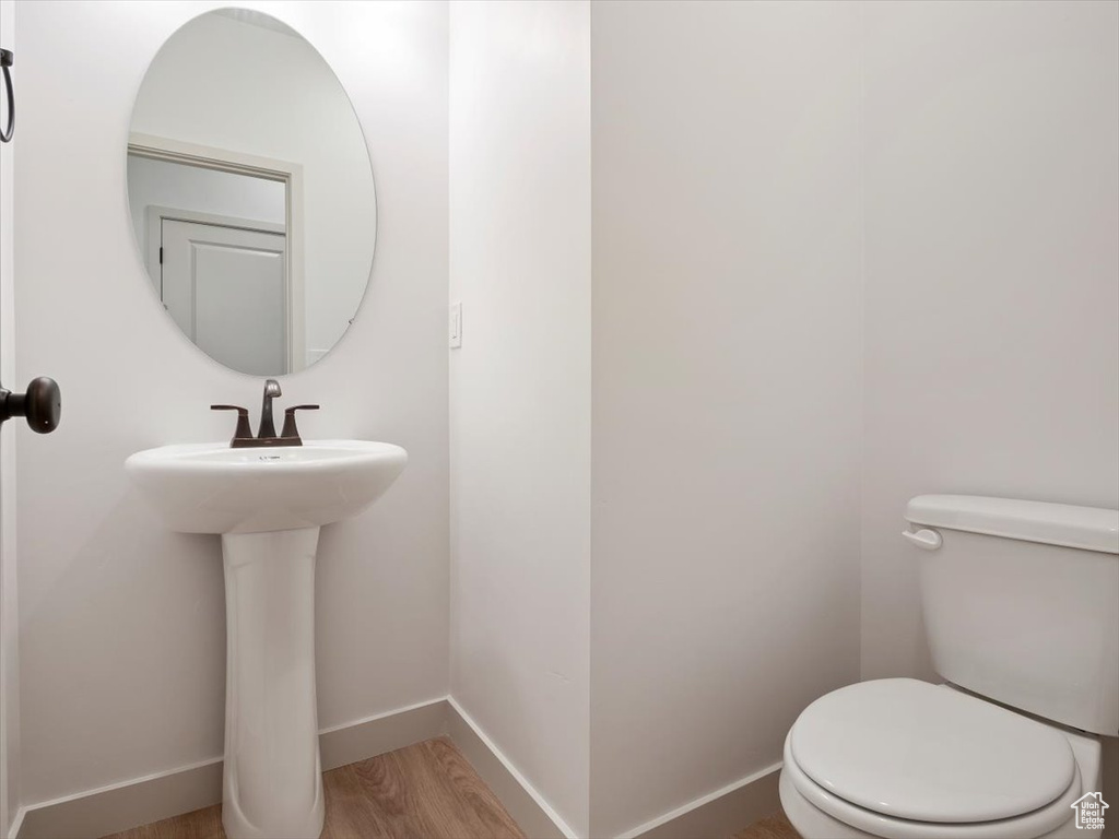 Bathroom featuring sink, hardwood / wood-style flooring, and toilet