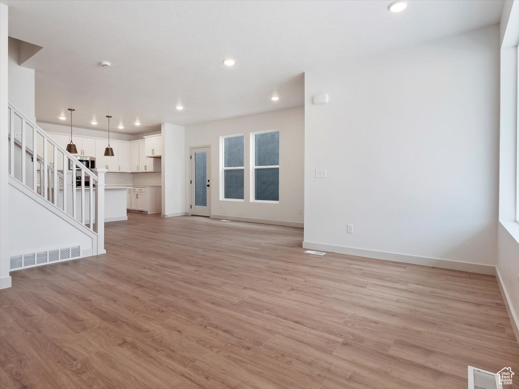 Unfurnished living room featuring light wood-type flooring