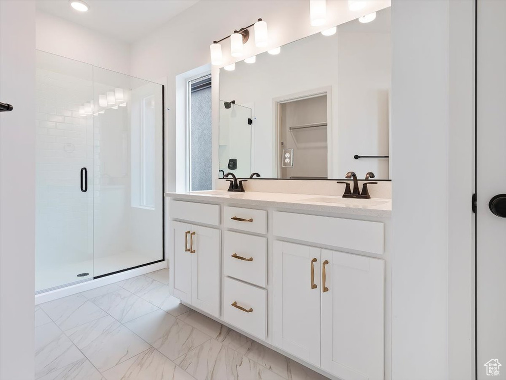 Bathroom with a shower with shower door and vanity