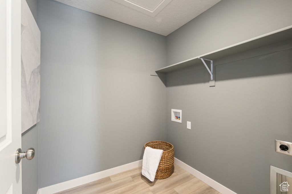 Laundry area featuring hookup for a washing machine, hardwood / wood-style floors, and electric dryer hookup