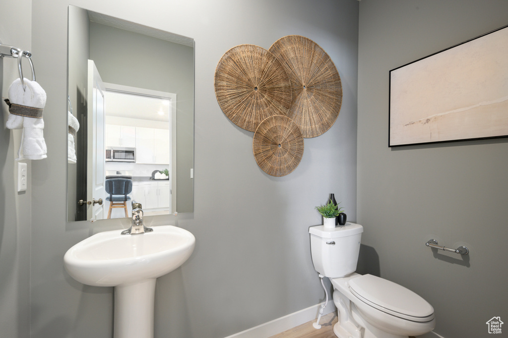 Bathroom with wood-type flooring, sink, and toilet