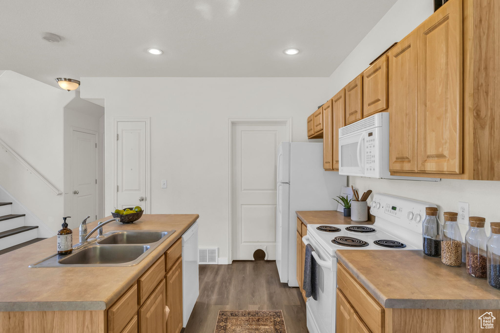 Kitchen featuring light brown cabinetry, dark hardwood / wood-style floors, sink, and white appliances